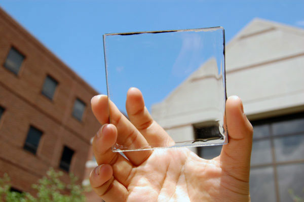 Researcher Yimu Zhao holding up a transparent luminescent solar concentrator module – Photography: Yimu Zhao